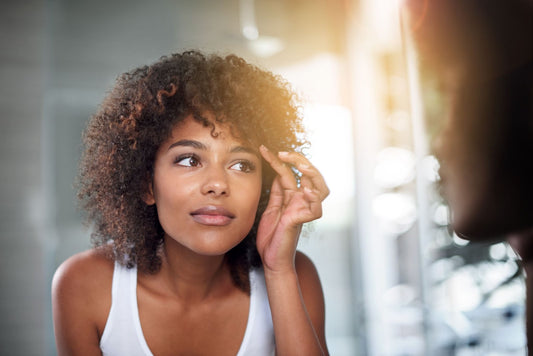 Woman looking in a mirror at her eyelashes that grew.