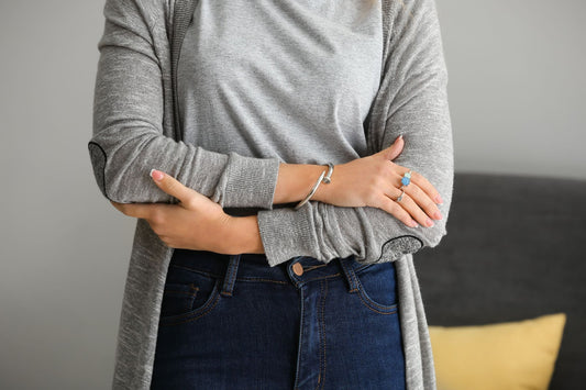 Woman with excoriation holding her arms.