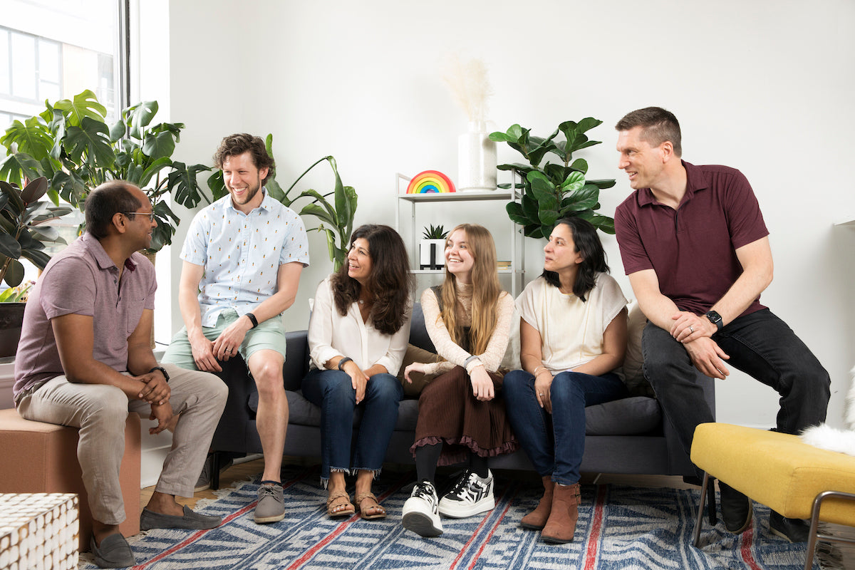 A group of people sitting on a couch in a living room.