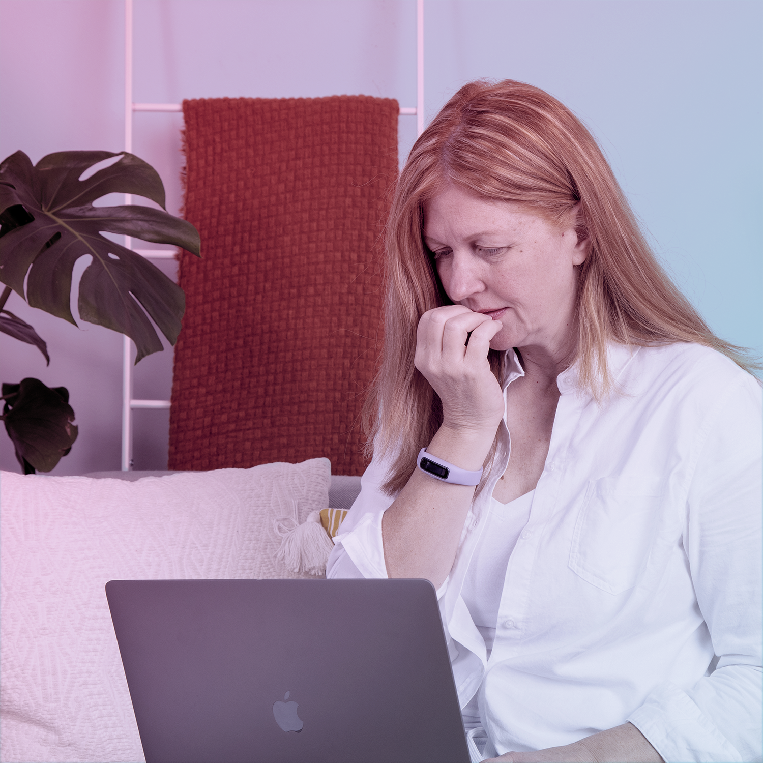 A woman sitting on a couch with a laptop.