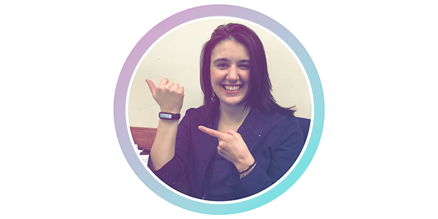 An image of a woman with a smart watch showing her thumbs up.