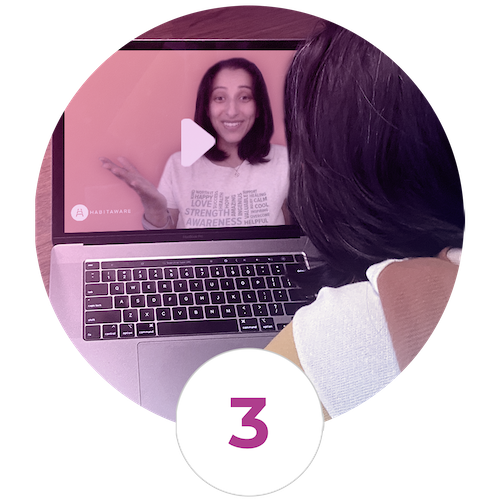 A woman is watching a video on a laptop screen.