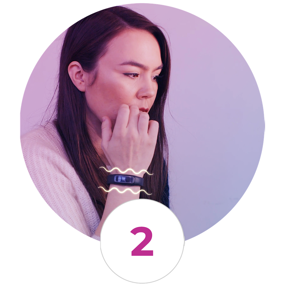 A woman wearing a bracelet with the number 2 on it.